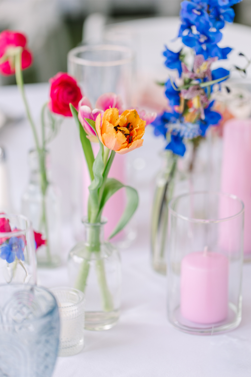 Colorful spring stems used in a clear glass bud vase centerpieces for a New Mexico wedding.