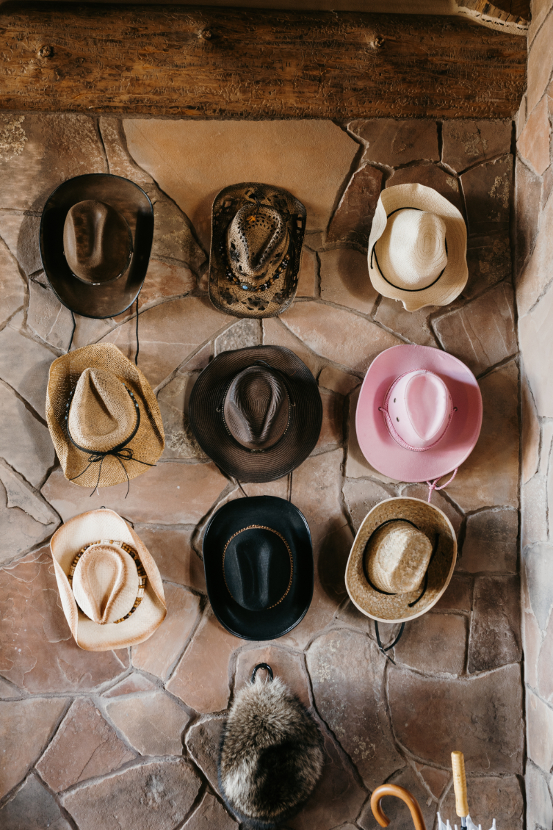 Display of cowboy hats hanging on a stone wall, one of the many country wedding ideas executed for this Tennessee wedding.