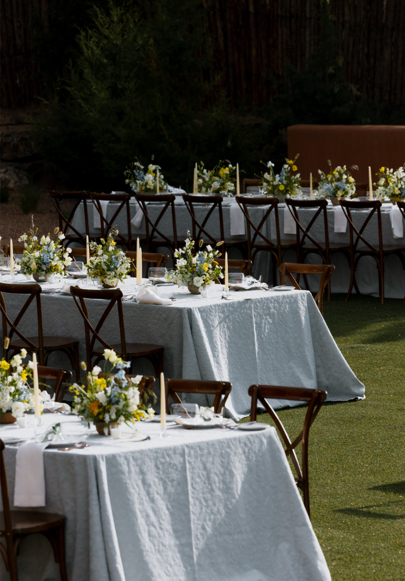 Reception tables decorated with fall wedding flowers in an organic arrangement.