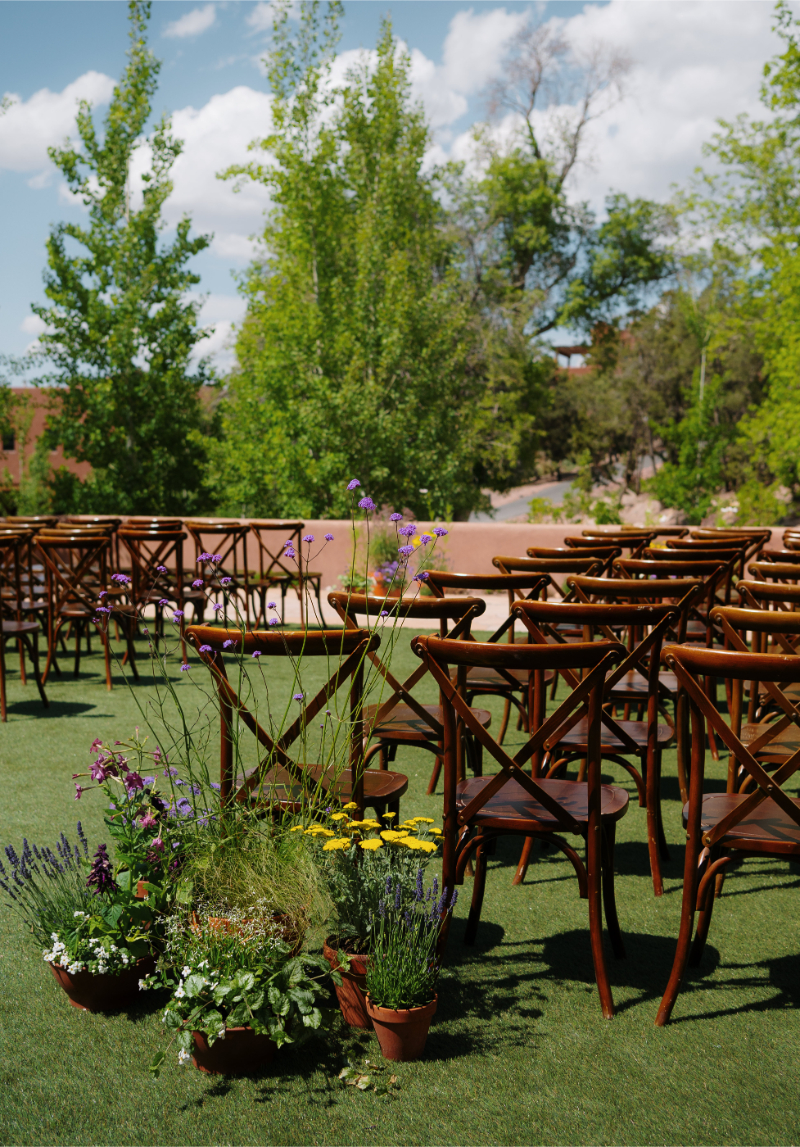 Fall wedding flowers in pots at the end of ceremony aisle for New Mexico celebration.