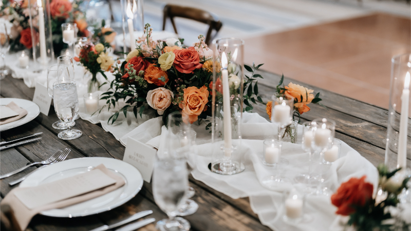 Wedding reception tablescape on dark wooden tables.