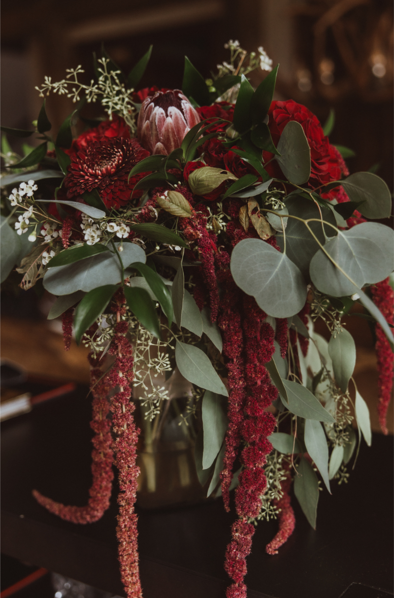 Large floral arrangement for a winter wedding in New Mexico, featuring Christmas wedding ideas color palette of reds and greens.