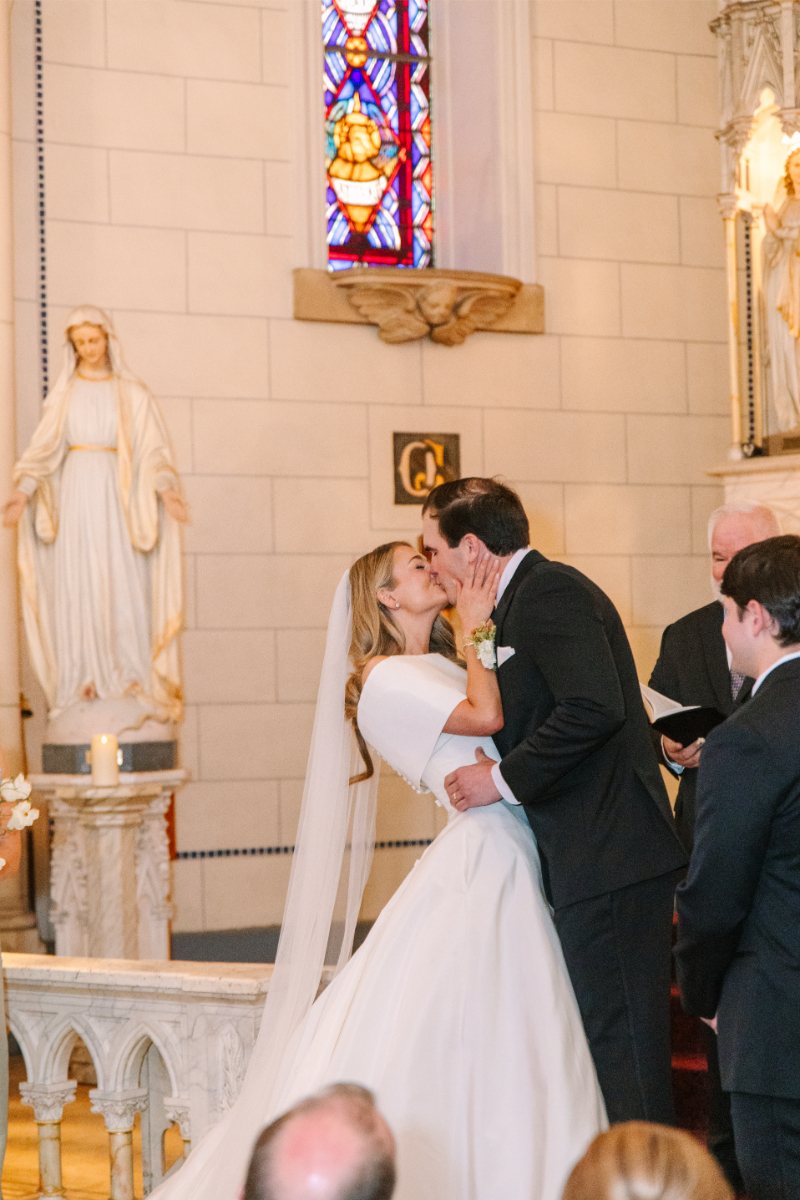 Bride and groom kiss at the altar.