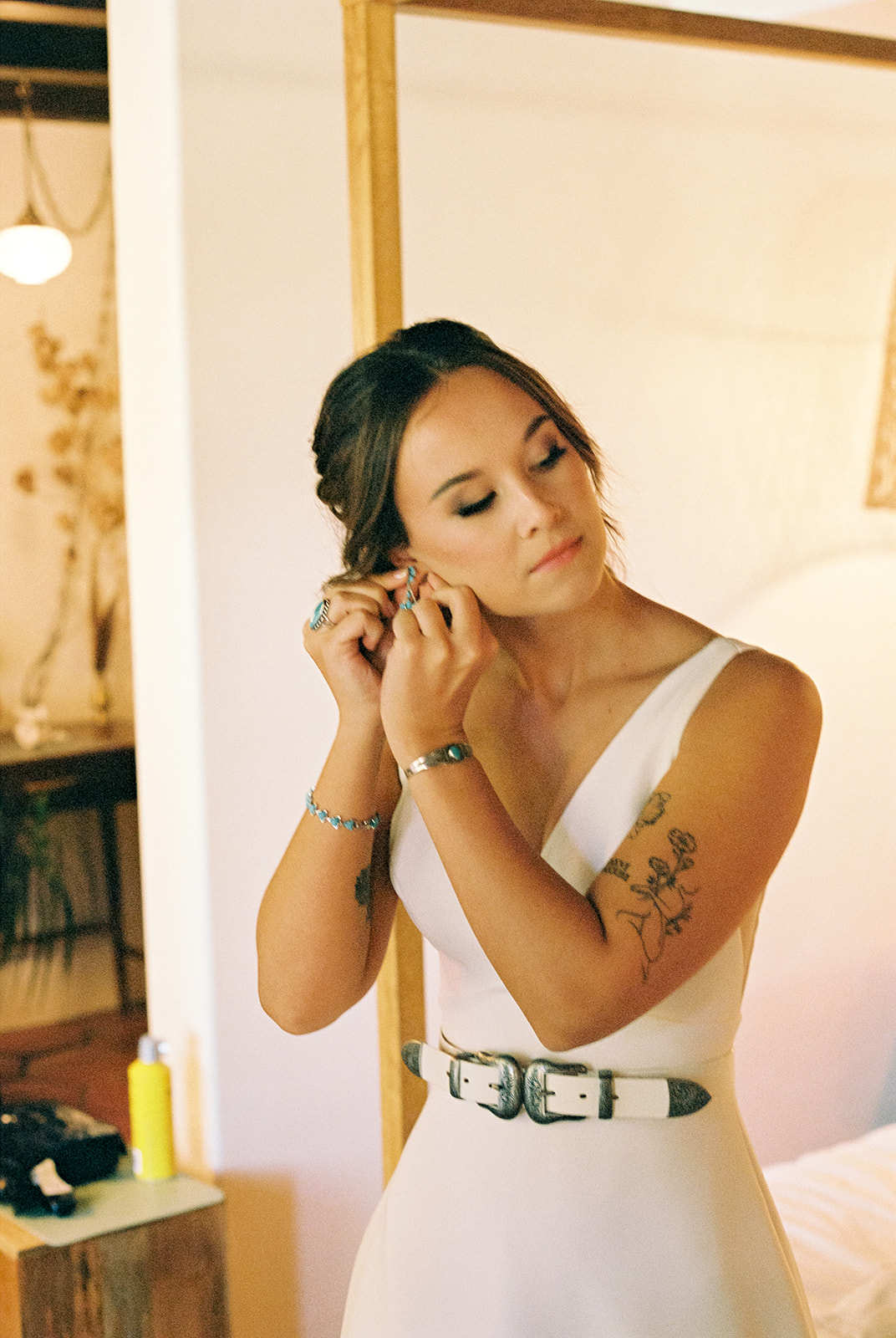 Bride puts earrings on as she gets ready for her western wedding in Tennessee.