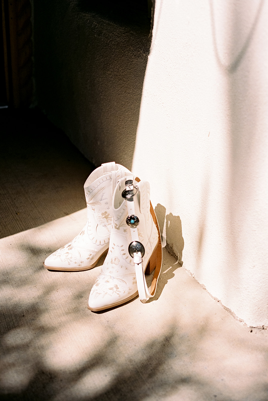 White ankle height boots worn by a bride for a western wedding theme.