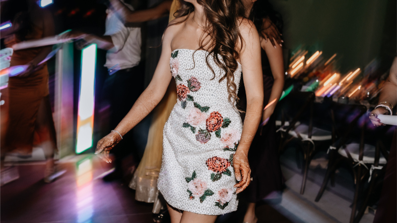 Close-up of a bride's beaded floral reception dress in motion on the dance floor.