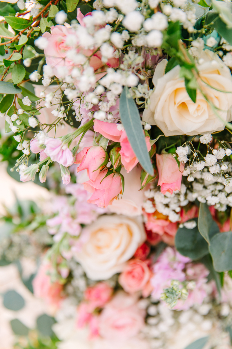 Close up of pink and green wedding ceremony arch covered in florals.