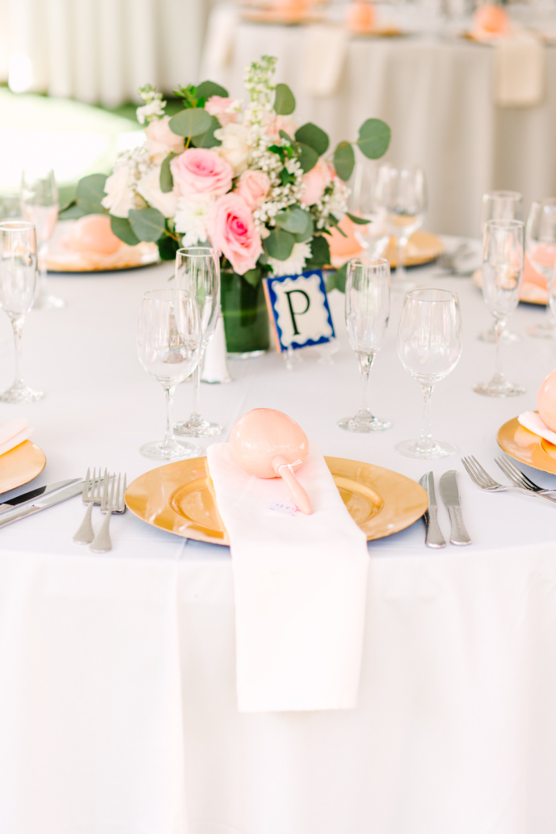 Round reception table decorated with pink and green decor pieces for a wedding in New Mexico.